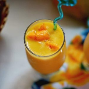 side close up view of mango milkshake with mango chunks