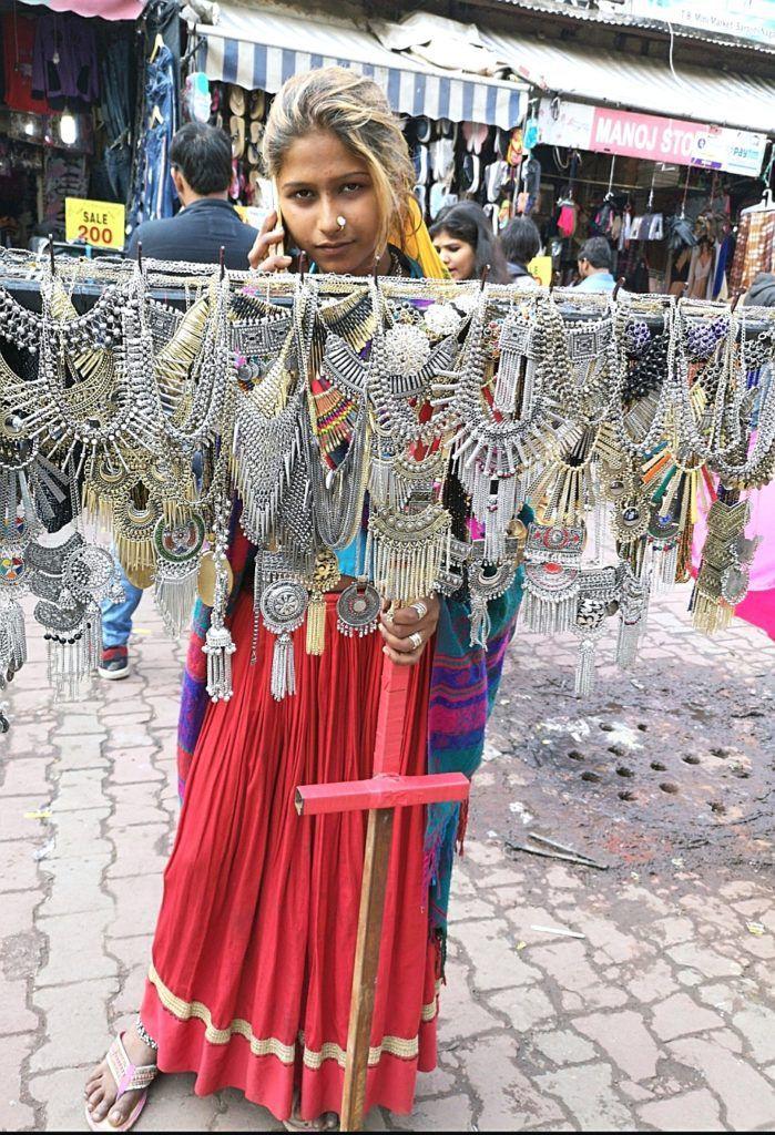 a lady holding rack of silver and Boho jewellery at  Sarojini Market, Delhi , Tips to shop at Sarojini Nagar Market, 