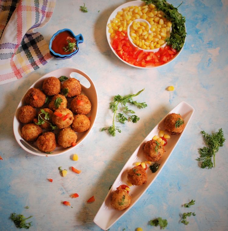 flat layout of crispy and crunchy cheese corn balls recipe served with boiled sweet corns and garnished with coriander leaves