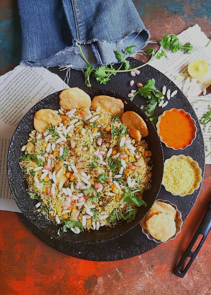 close up view of Bhel Puri served with papdis, nylon sev, garlic chutney and ready to be served