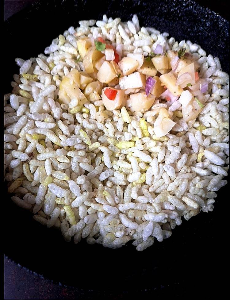 mixing boiled potatoed to the roasted puffed rice,  how to make street style bhel puri at home