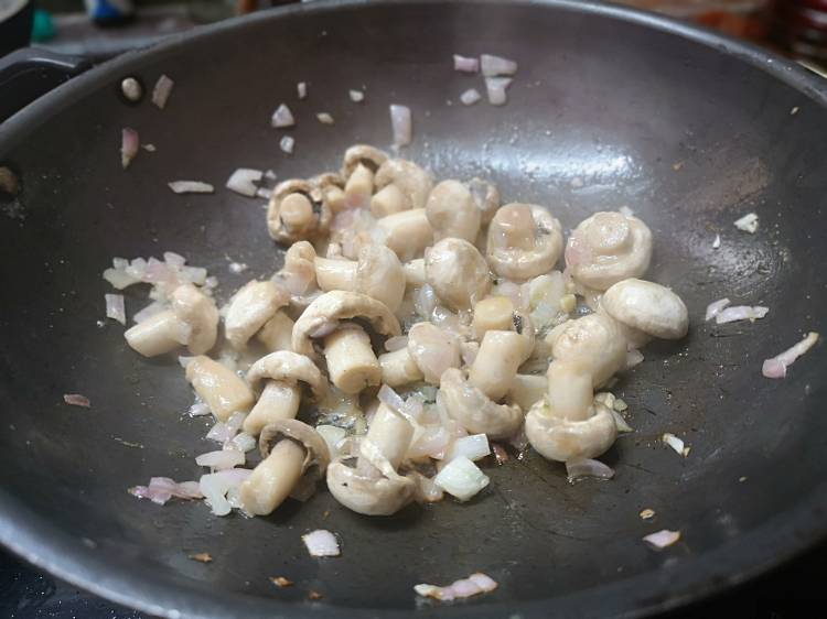 cooking mushroom and onion in a kadai