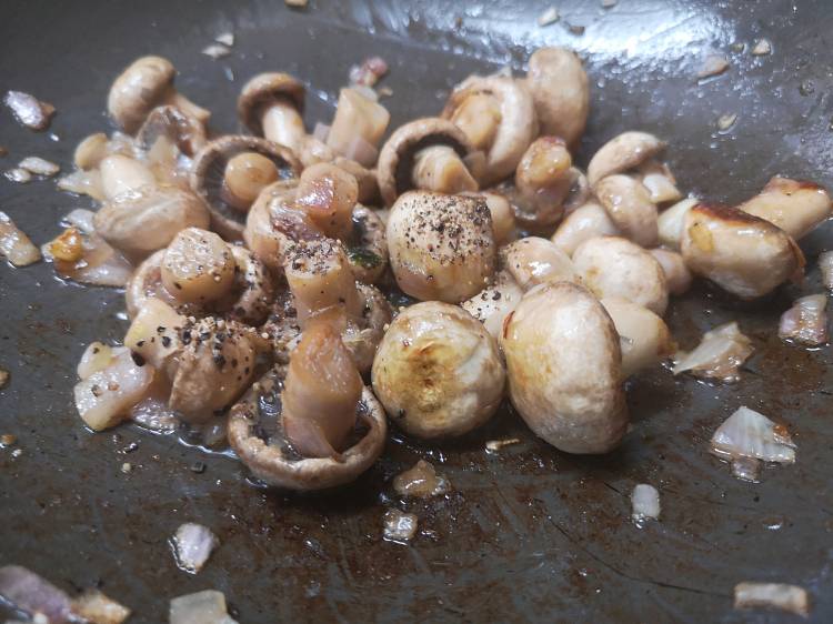 adding black pepper powder into the garlic mushroom