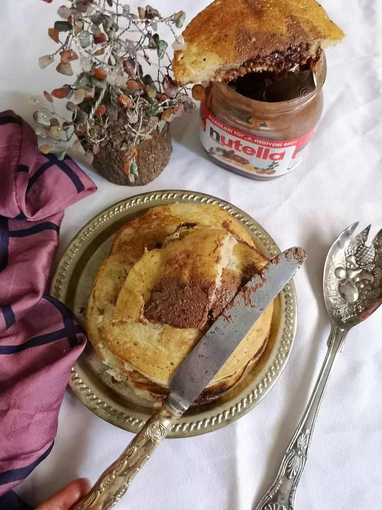 overhead photo of Nutella Pancakes ready to serve with some Nutella spread on top of it.