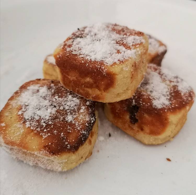 Dusting Russian Cheese squares with powdered sugar, ready to be served