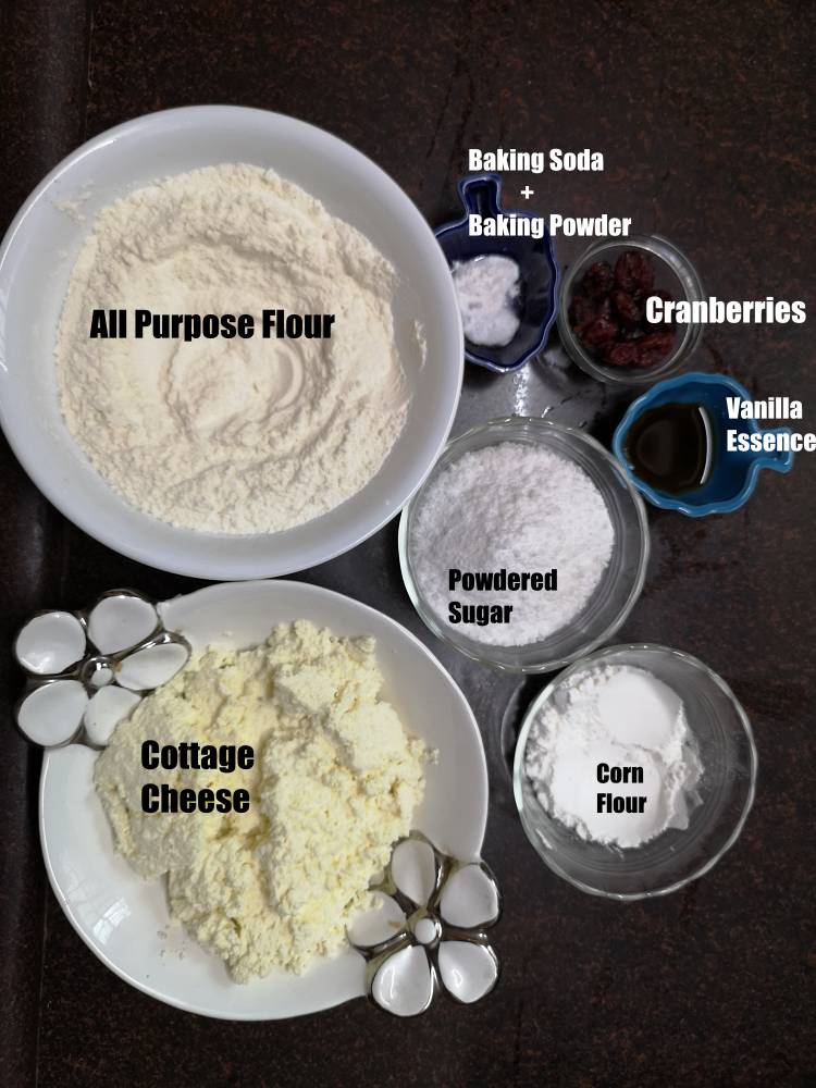 all purpose flour, baking soda, baking powder, cranberries, vanilla essence, powdered sugar,cottage cheese and corn flour for preparing Russian Syrniki recipe