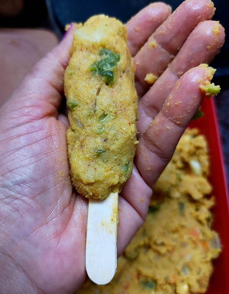 rolling veg kababs and inserting into an ice cream stick