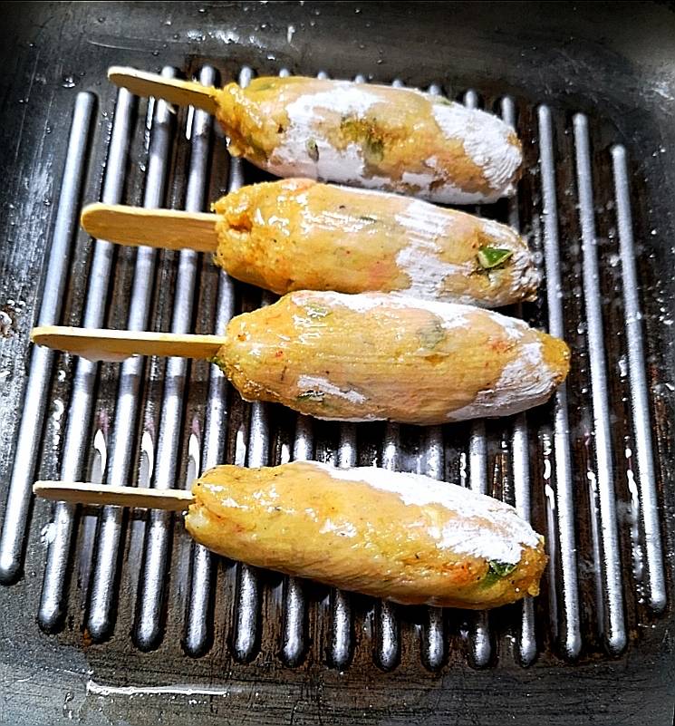 cooking veg kababs on grill pan and brushing them with oil