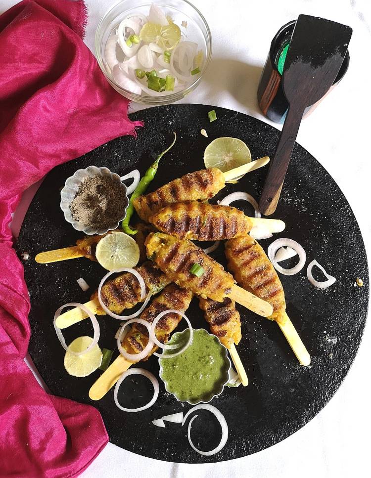  overhead photo of veg kababs served in an ice cream stich and served with lemon  and onion slices, how to make veg kabas at home