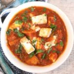 close up view of delicious aloo paneer served in a white bowl with white board and a blue napkin, how to make aloo paneer