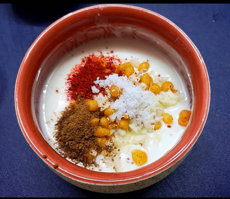 adding salt, red chili powder, cumin powder to the yogurt for preparing burhani raita