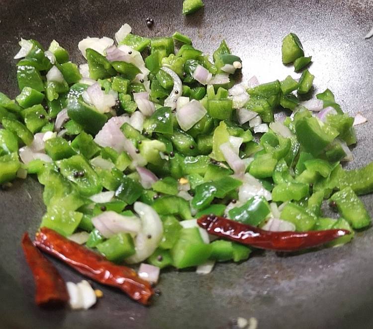 how to make Capsicum Raita or Shimla Mirch Raita . sauteing onion and capsicum into oil along with red chili and mustard seeds