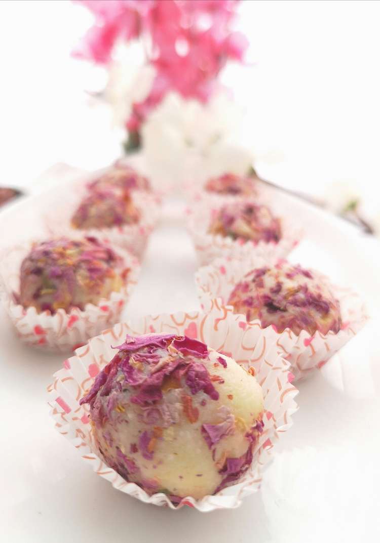 close up view of coconut truffles, rolled with rose petals, how to make coconut truffles at home