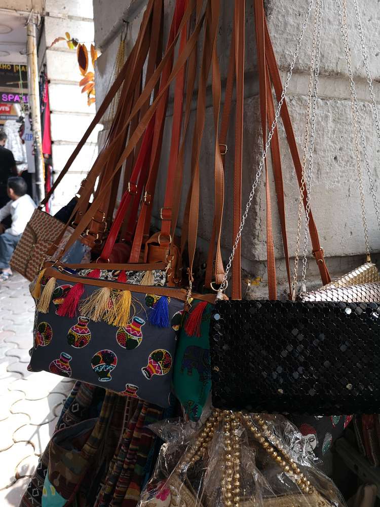 blog on Colaba Causeway Shopping Tips and Tricks, beautiful artificial leather handbags and slings displayed at colaba market