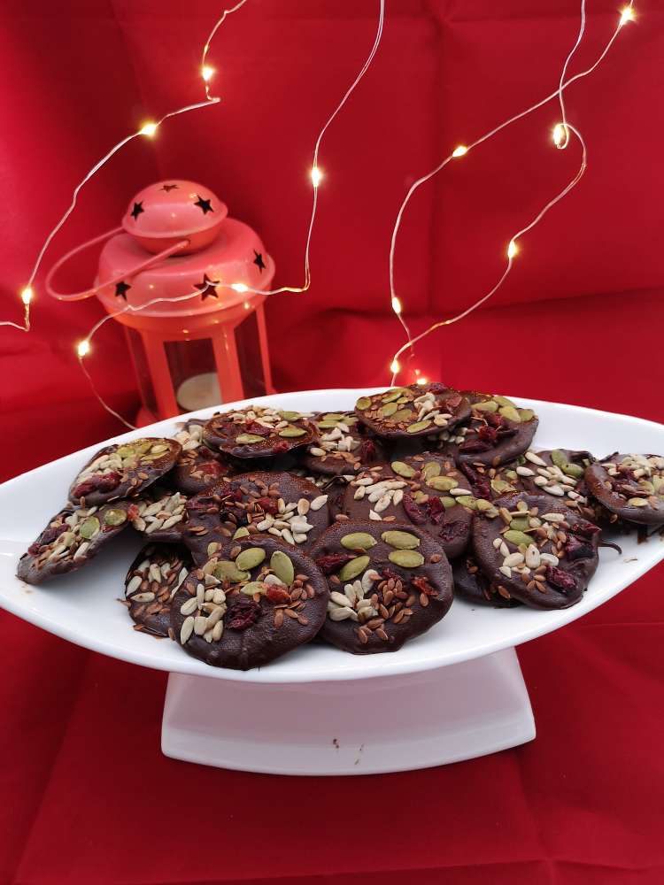 Detox Chocolate Bites served on a white plate with red runner, candle stand and fairy lights