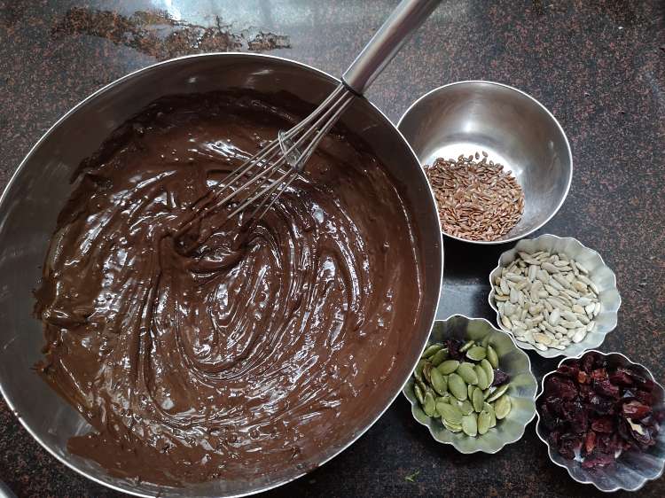 Chocolate, flax seeds, pumpkin seeds, sunflower seeds and cranberries for preparing detox chocolate bites