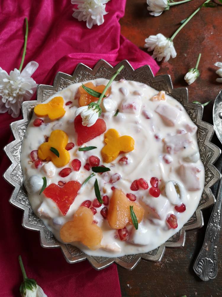close up view of easy fruit cream recipe garnished with mangoes, watermelon, pomegranates and grapes