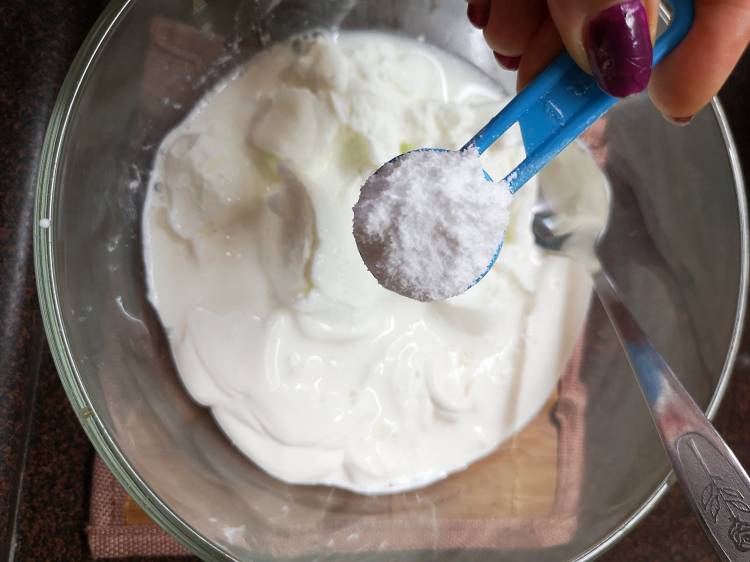 adding icing sugar to the bowl for Fruit cream recipe 