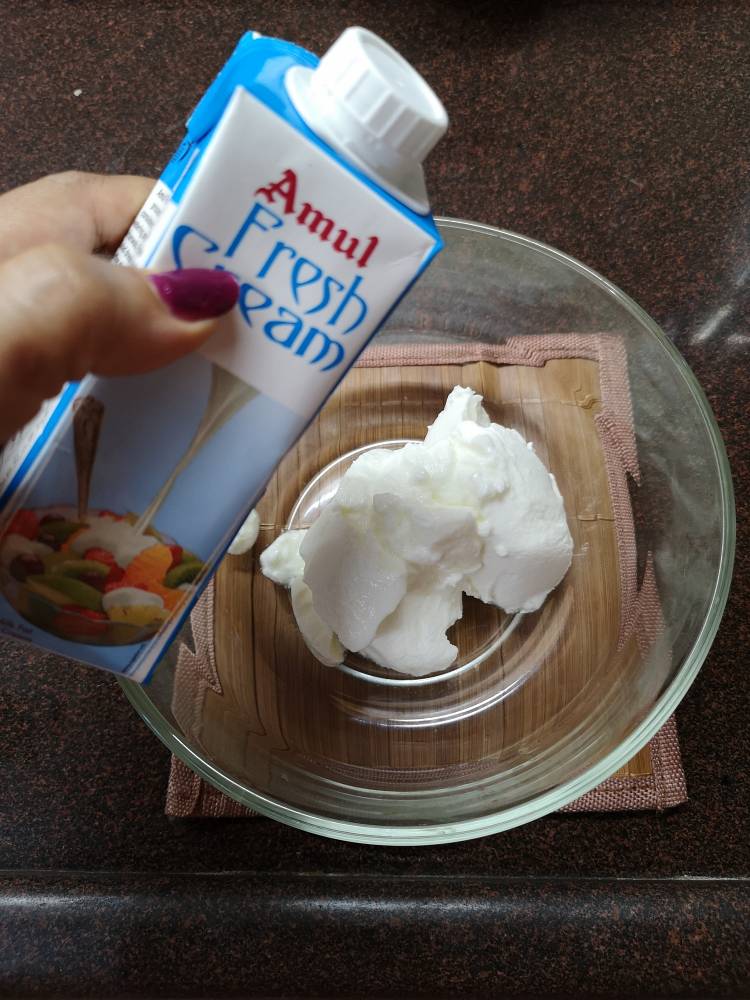 adding fresh cream into the yogurt, curd for Fruit cream recipe 