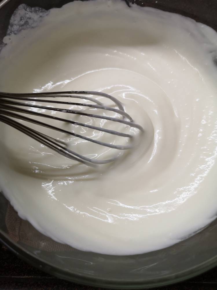 whisking yogurt and fresh cream for Fruit cream recipe 