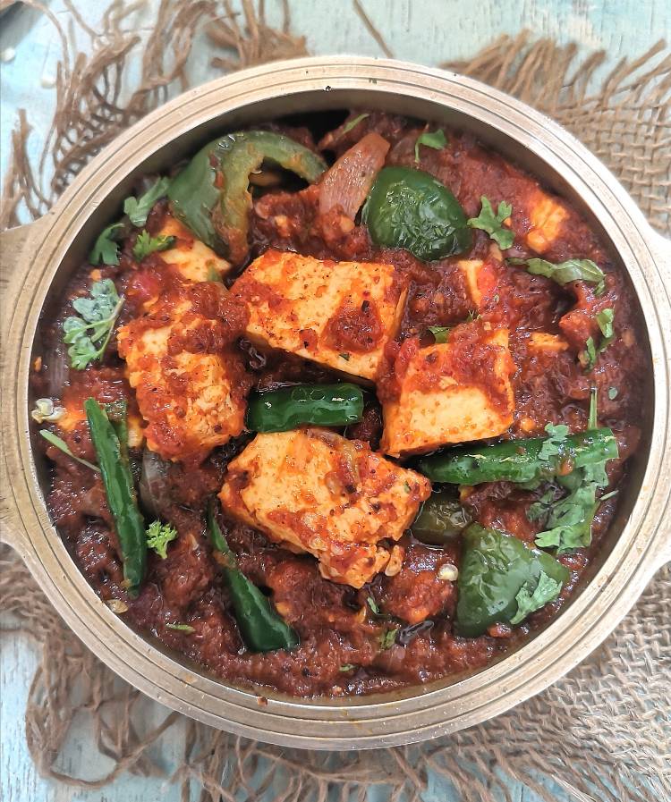 close up view of Kadai Paneer Masala, paneer served with green bell peppers, onions and green chillies