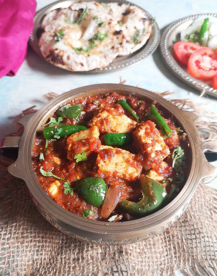 close up view of Kadai paneer masala served with butter roti, tomatoes and onion slices | Kadai Paneer Masala | Kadai Paneer Sabzi | Kadai Paneer