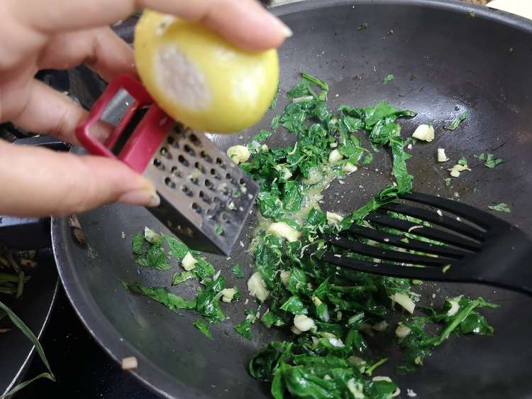adding lemon zest to spinach and garlic for lemon pasta