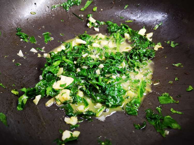 close up view of wilted spinach, minced garlic and melted butter in a pan, How to make Pasta al Limone