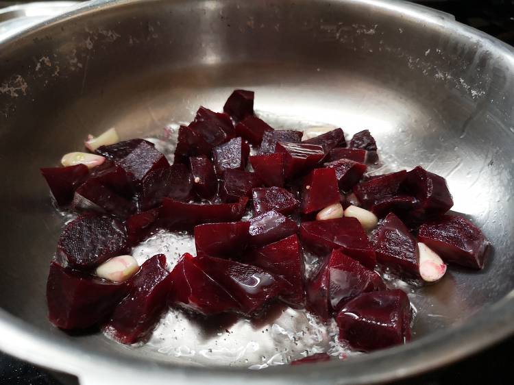 sauteing boiled and chopped beetroot and garlic cloves for roasted beetroot hummus 