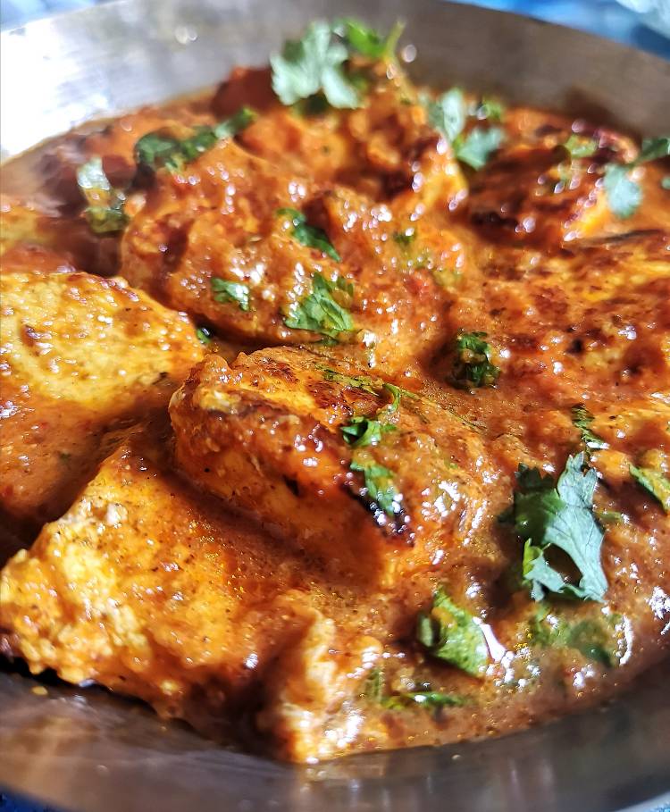 close up of tawa paneer masala simmered in gravy and garnished with fresh coriander leaves / how to make restaurant style tawa paneer masala at home / recipe of tawa paneer masala