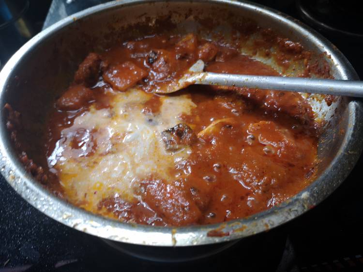 adding fresh cream into the paneer cubes onion tomato gravy for tawa paneer masala
