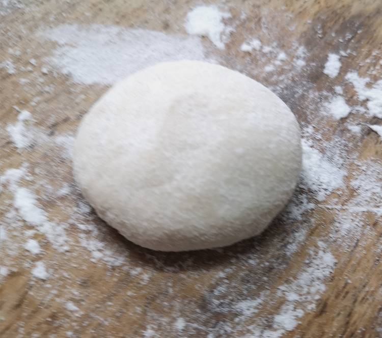 pinching a lemon size dough for rolling Bhatura