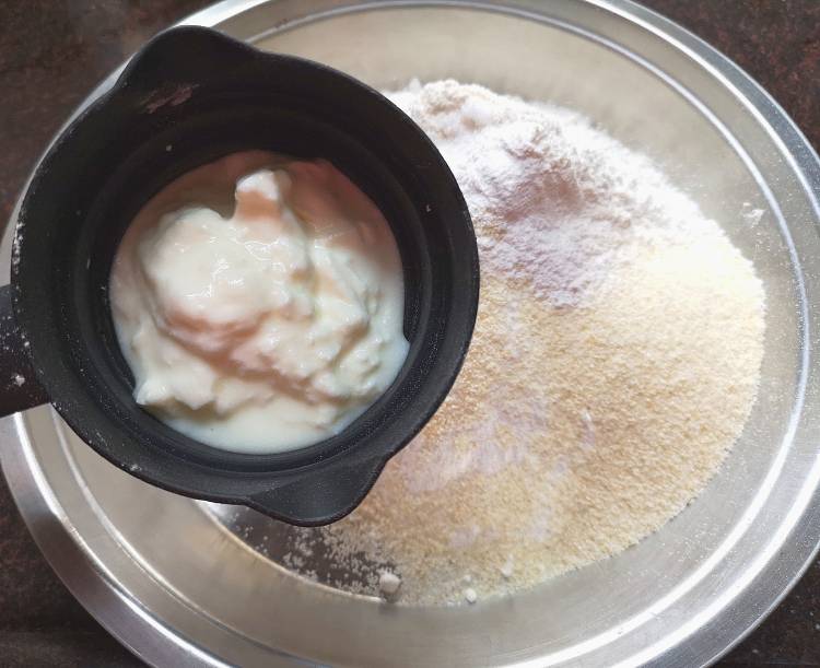 adding curd ine all-purpose flour, semolina to prepare bhatura recipe
