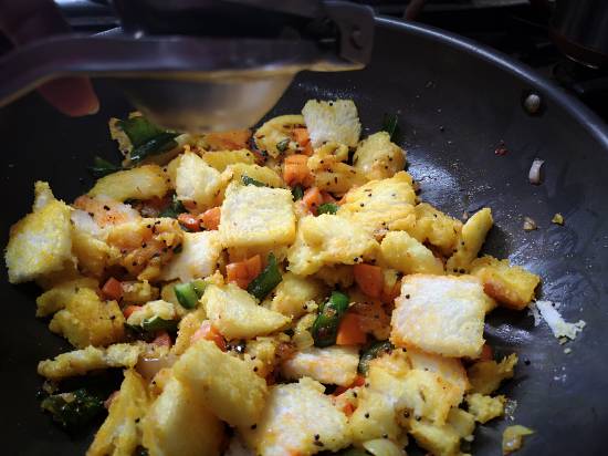 mixing bread pieces, vegetables and spices for preparing Bread Upma recipe, South Indian Style Bread Upma