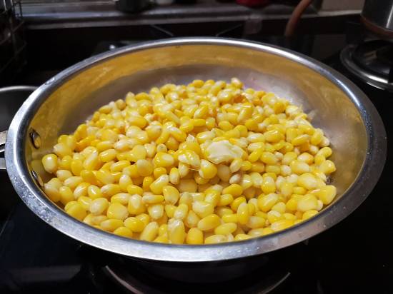adding boiled butter corn in the pan along with butter