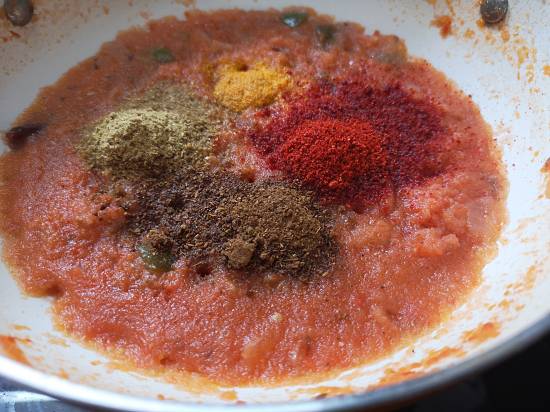 Adding turmeric powder, garam masala, kashmiri chili powder, Coriander powder in onion tomato gravy 