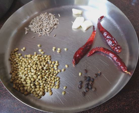 close up photo of dry ingredients like dry chilies, turmeric powder, pepper, cumin, and coriander seeds needed to prepare Mysore Rasam