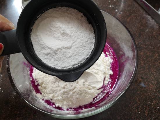 adding iciing sugar to the pancake batter, pink pitaya pancakes recipe