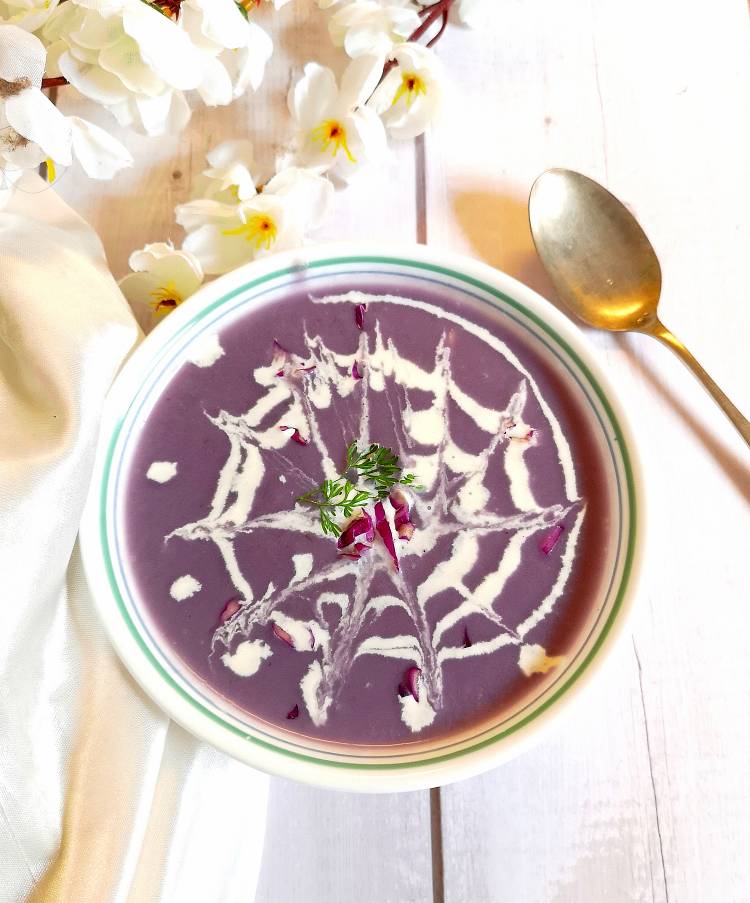 Overhead photo of Purple Cabbage Soup topped with fresh cream, ready to be served