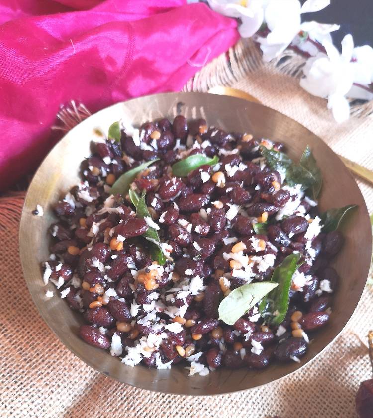 rajma sundal served in a brass bowl and garnished with fresh coconut and curry leaves