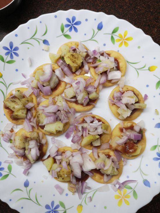 adding chopped onions for Mumbai sev puri recipe