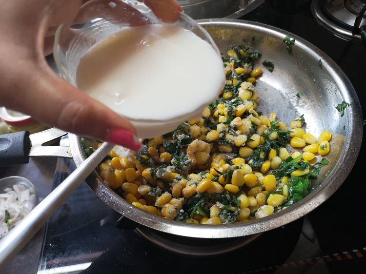 pouring milk into the spinach corn mixture for sandwich
