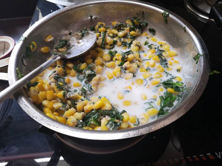 boiling milk into the spinach, sweet corn filling for sandwich