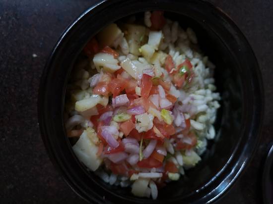 adding chopped onions, tomatoes and boiled potatoes in puffed rice
