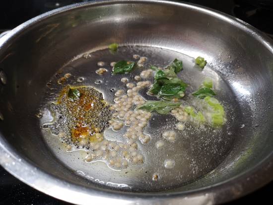 adding mustard seeds and curry leaves in the tomato rice tadka