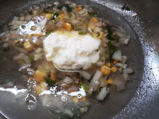 addind curd to the boiling water for Rava Upma