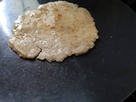 applying ghee on amaranth flour parathas in rajgira paratha recipe | navratri recipes