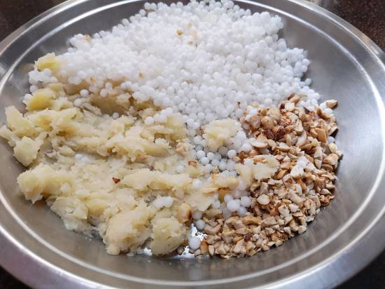 mashing boiled potatoes to mix in soaked sabudana and roasted peanuts