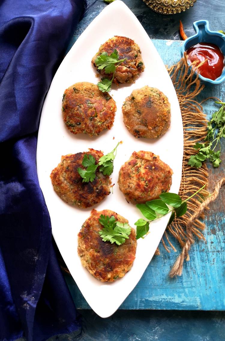 top view of crispy and golden sweet potato tikkis garnished with coriander leaves 