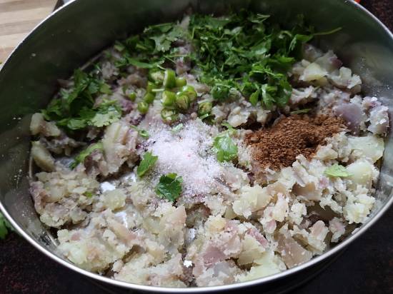 adding Sendha Namak, green chilies, coriander leaves, cumin powder  to mashed sweet potatoes for preparing sweet potato tikkis recipe